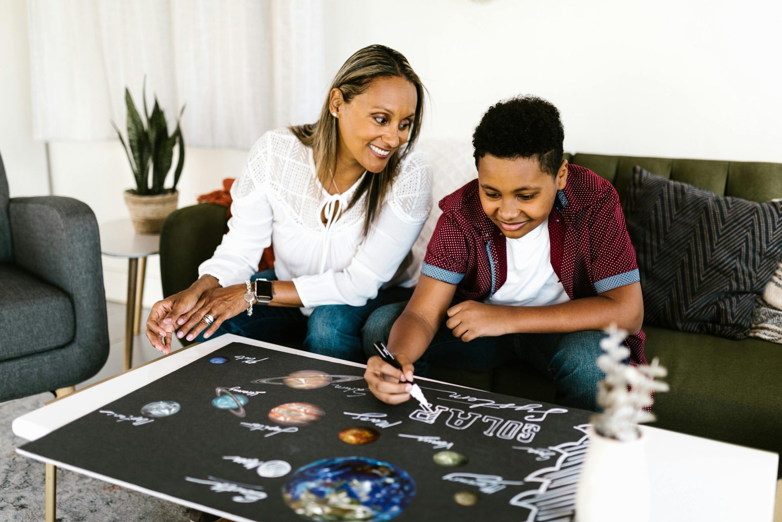 Parent helping a child build a solar-system project at home