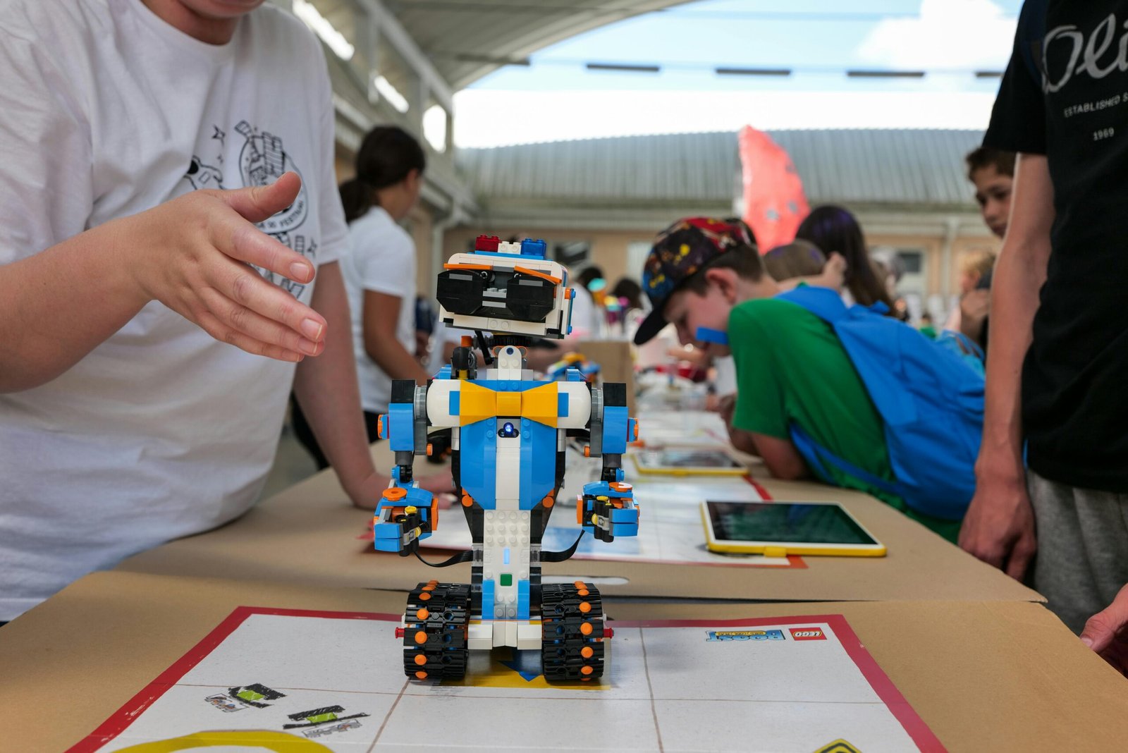Colourful learning robot surrounded by students at a workshop