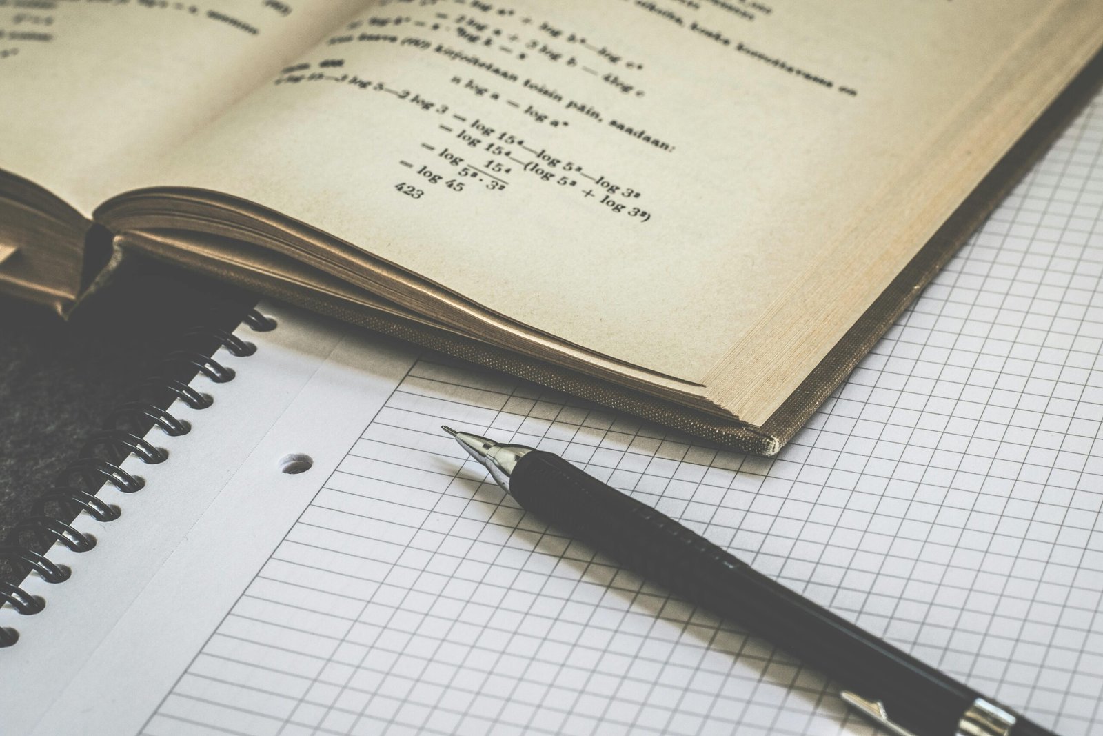Mathematics book, notebook, and pen prepared for a short revision session
