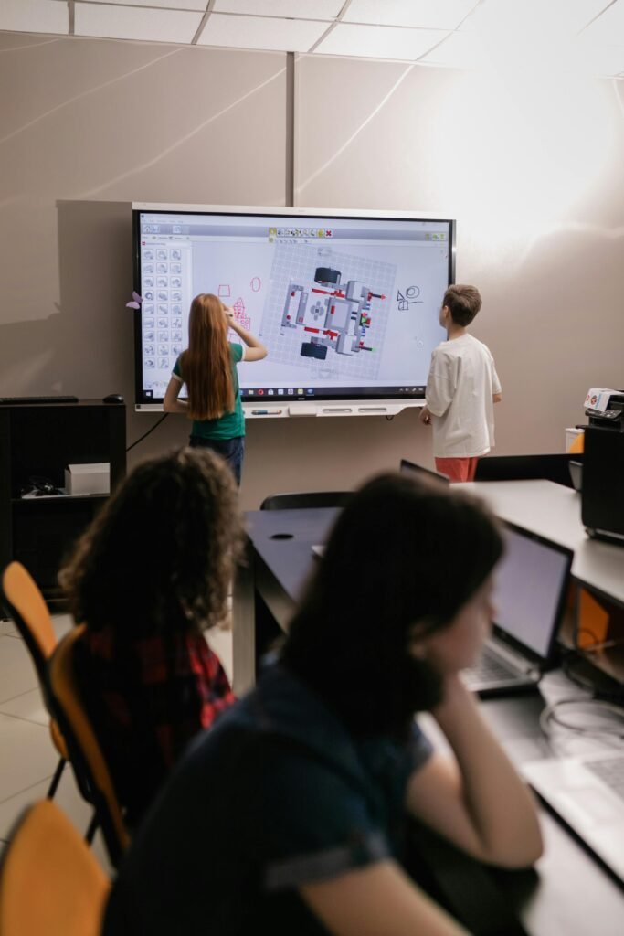 Students actively participate in a computer lab session, demonstrating the shift toward digital literacy and technology-focused education.
