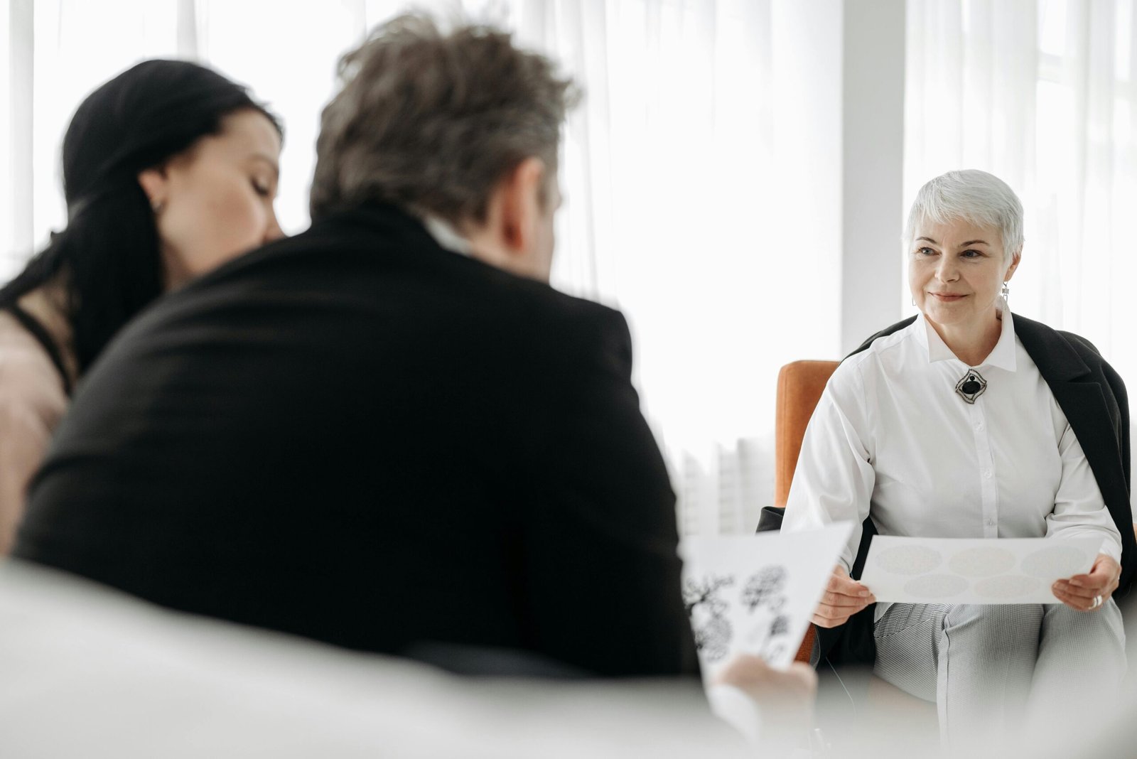 Teacher discussing a student's work with two parents during a meeting