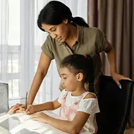 Parent helping a child study at a computer